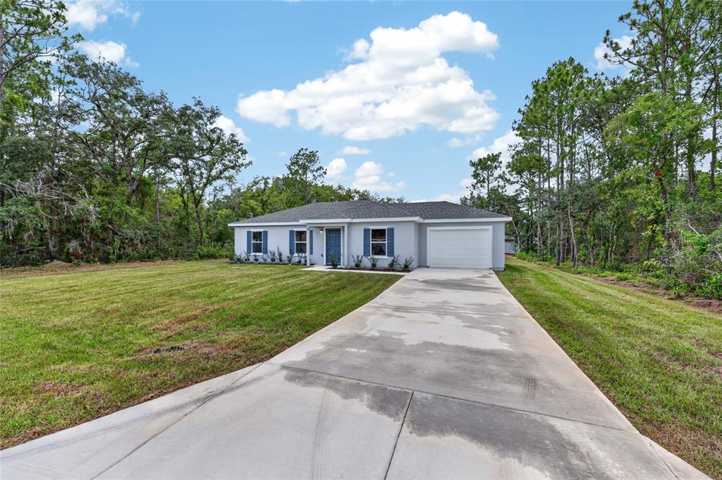 A single-story house with a gray exterior, blue shutters, and a concrete driveway — 6 FIR DRIVE TRACK, OCALA, FL