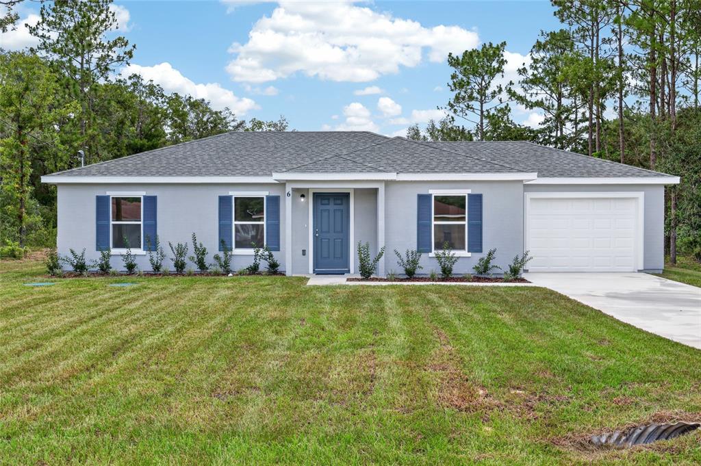 A single-story house with gray siding, blue shutters, a front door, and a one-car garage — 6 FIR DRIVE TRACK, OCALA, FL