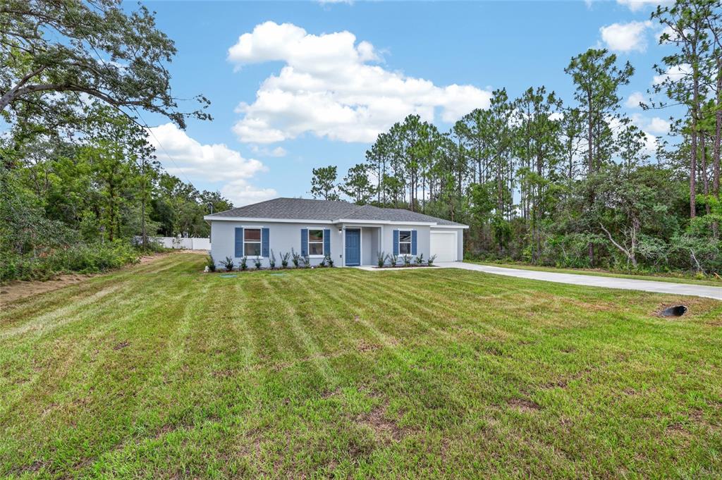 A single-story house with a gray exterior, blue shutters, and a concrete driveway — 6 FIR DRIVE TRACK, OCALA, FL