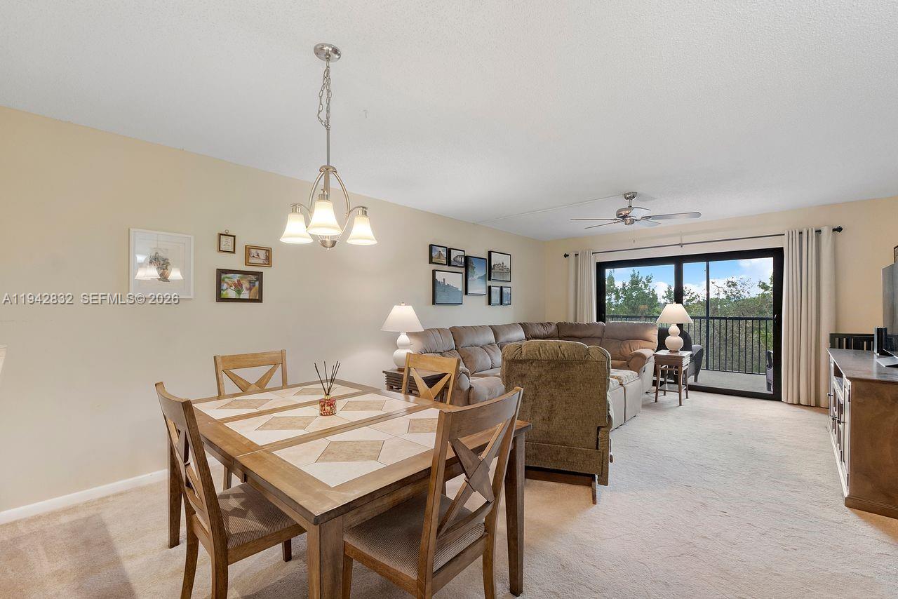 A kitchen with dark wood cabinets, white appliances, and a small dining table — 2200 S Cypress Bend Dr # 406, Pompano Beach FL 33069, POMPANO BEACH, FL