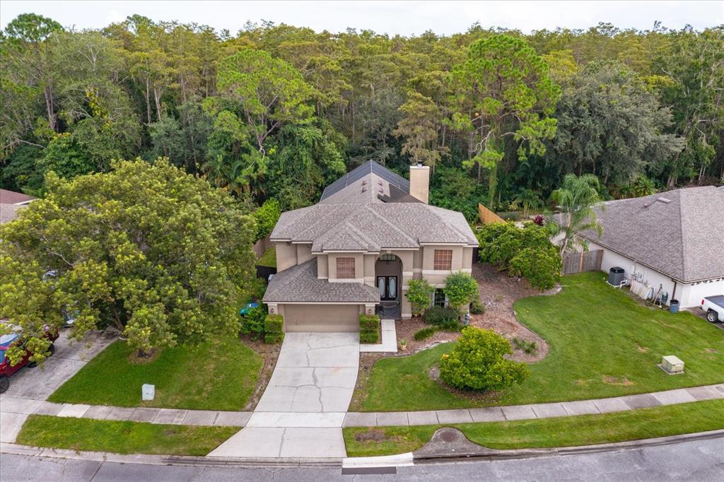 An aerial view of a two-story suburban house with a driveway and a wooded backyard — 3920 RUNNING WATER DRIVE, ORLANDO, FL