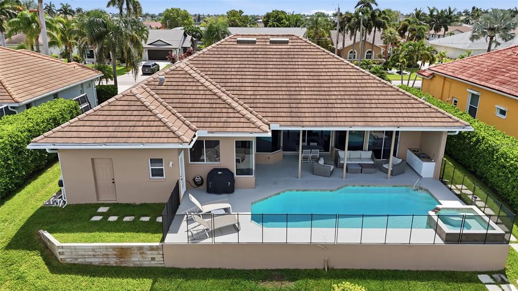 An aerial view of a house exterior featuring a swimming pool, spa, and patio area — 5020 SW 8TH PLACE, CAPE CORAL, FL