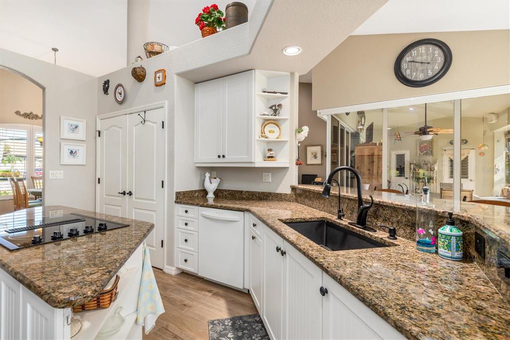 A kitchen features white cabinets, granite countertops, a black sink, and a center island — 590 TOULOUSE DRIVE, PUNTA GORDA, FL
