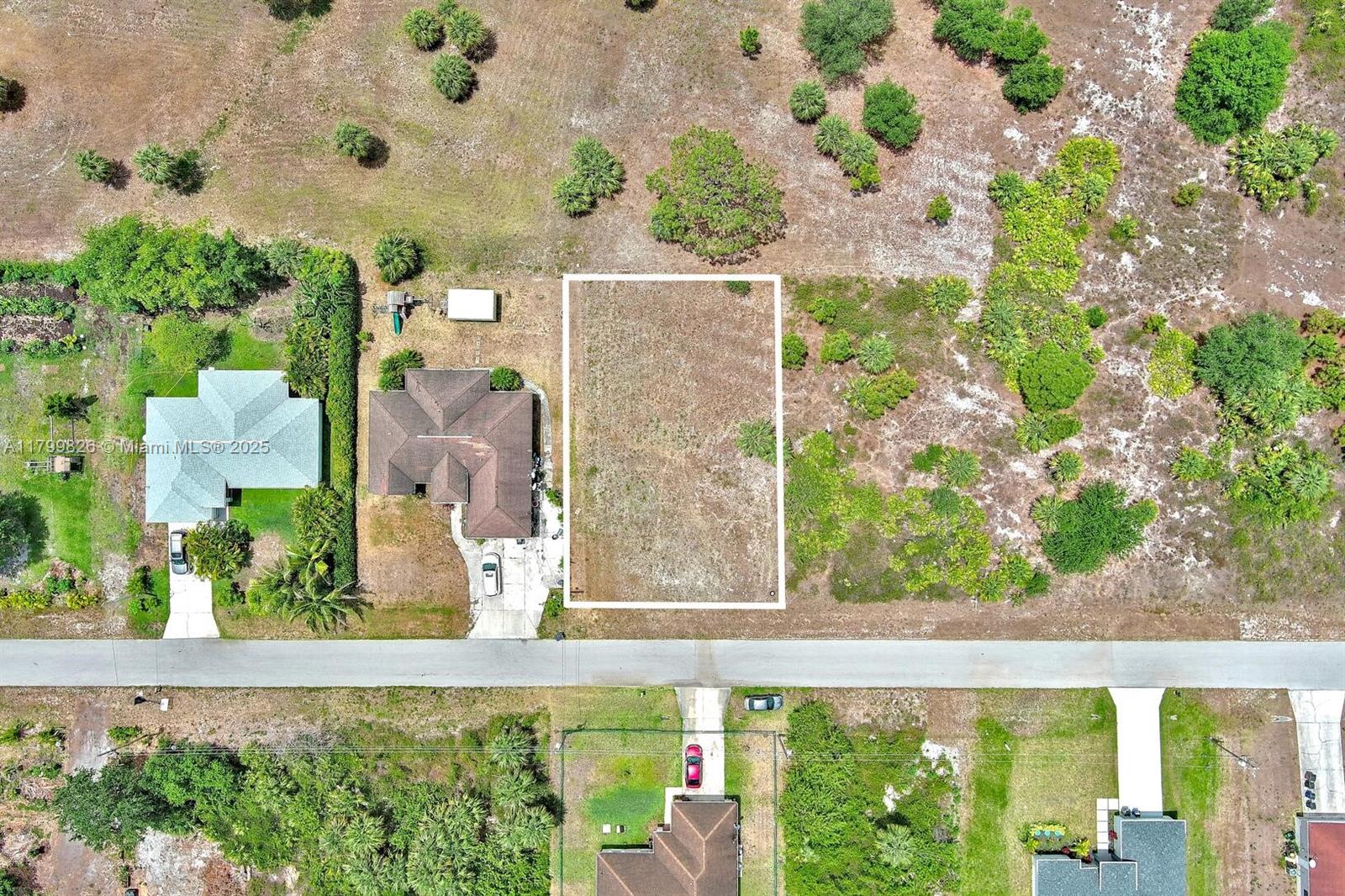 An aerial view shows a vacant rectangular lot outlined in white next to a house — 914 S Mercury Ave, Lehigh Acres FL 33974, LEHIGH ACRES, FL