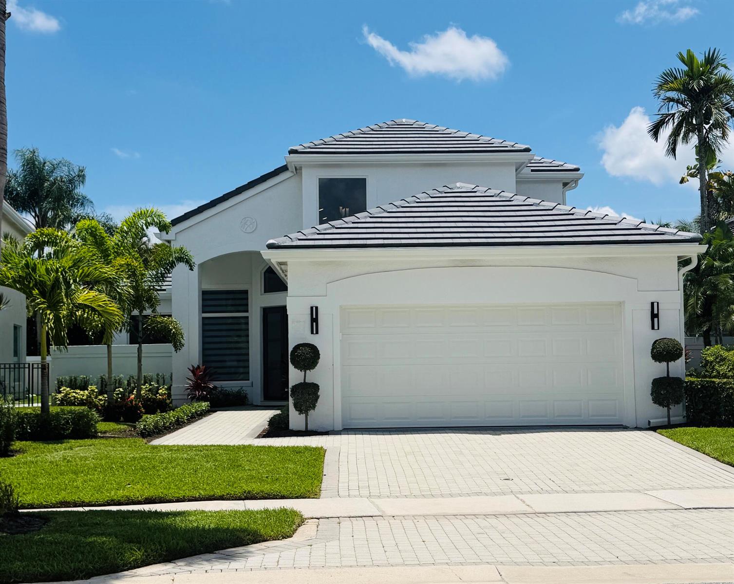 A white two-story house with a gray tile roof, a two-car garage, and palm trees — 3368 NW 53rd Circle, Boca Raton FL 33496, BOCA RATON, FL