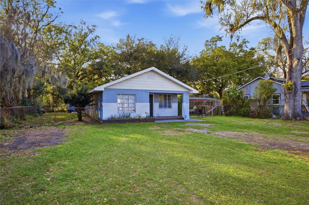 A single-story house with blue and white painted brick siding sits on a grassy lot — 907 CENTER STREET, PLANT CITY, FL