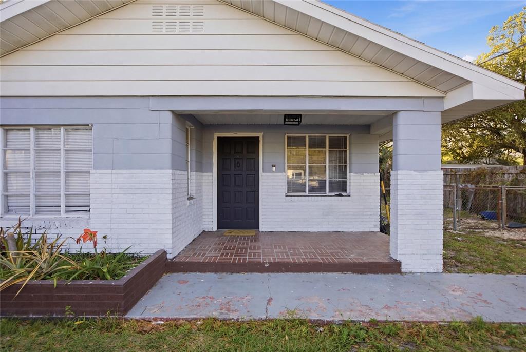 A single-story house with a covered front porch, brick accents, and a dark front door — 907 CENTER STREET, PLANT CITY, FL