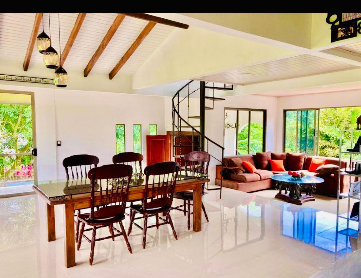An open-concept living and dining area features a spiral staircase, wooden furniture, and large windows — 141 N El Tanque Fortuna San Carlos Street, FL