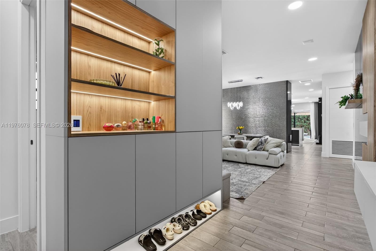 A modern entryway features a grey storage unit with built-in shelving and a shoe rack — 11174 NW 72nd Pl, Parkland FL 33076, PARKLAND, FL