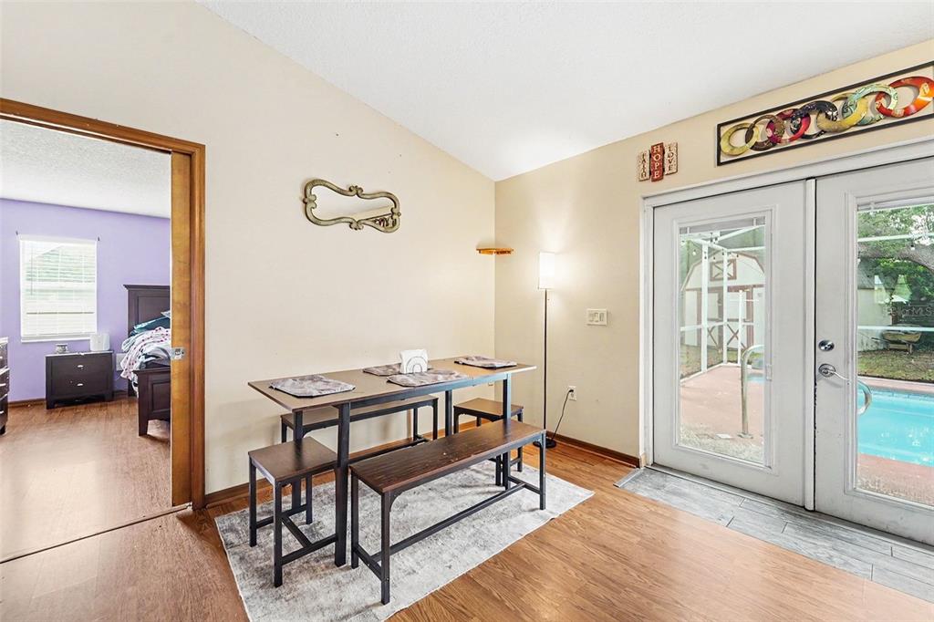 A dining area with a wooden table and benches sits beside a sliding glass door — 11363 NORVELL ROAD, SPRING HILL, FL