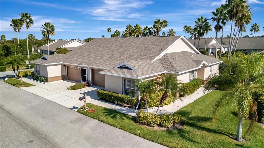 An exterior view of a tan duplex home with a shingled roof and palm trees — 2905 CAPTAINS COURT UNIT 0, PALMETTO, FL