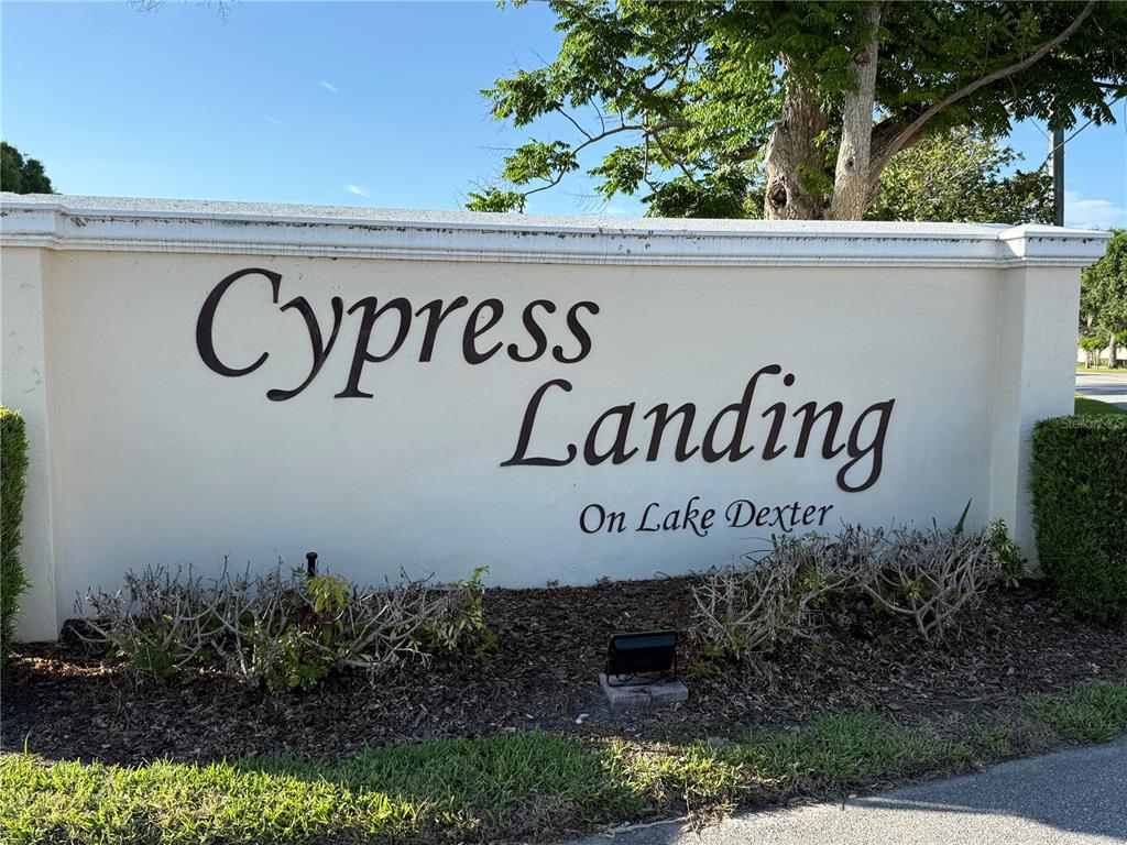 A beige stucco monument sign displays the words Cypress Landing On Lake Dexter — 3971 CYPRESS LANDING W, WINTER HAVEN, FL