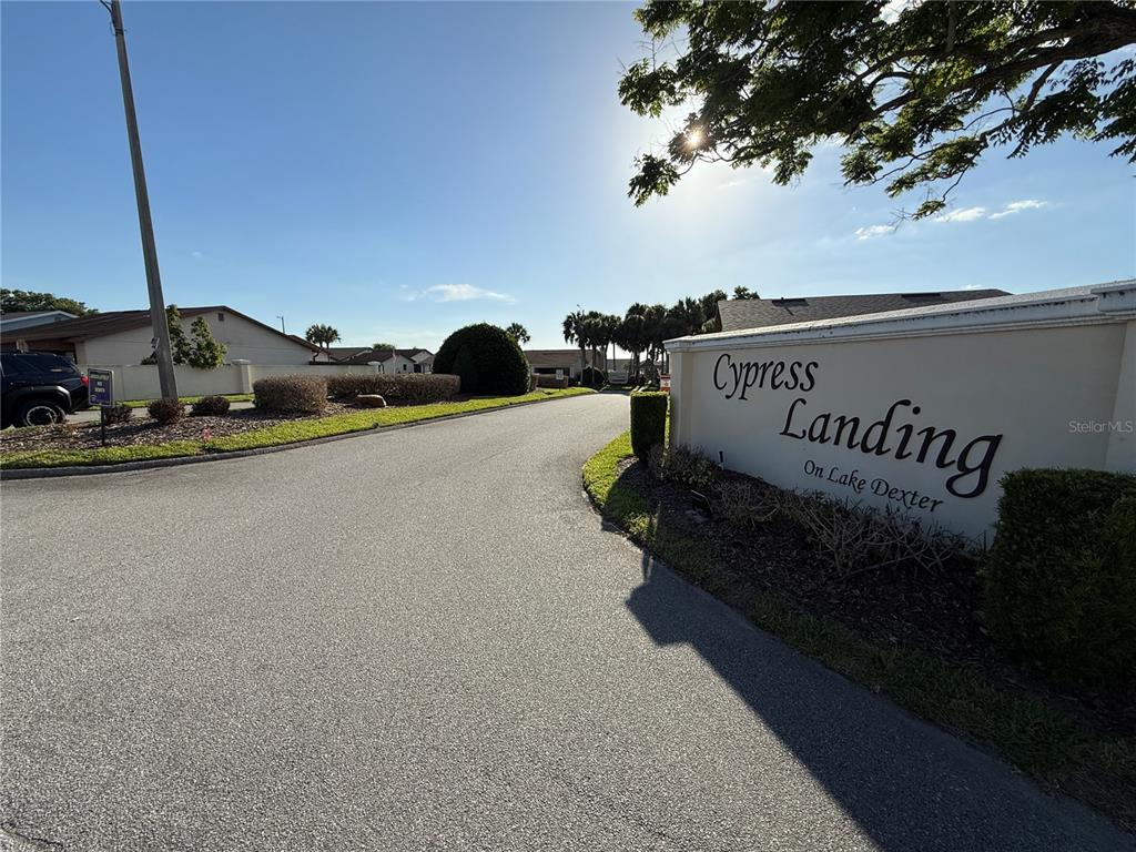 A paved road leads into the Cypress Landing on Lake Dexter residential community entrance — 3971 CYPRESS LANDING W, WINTER HAVEN, FL