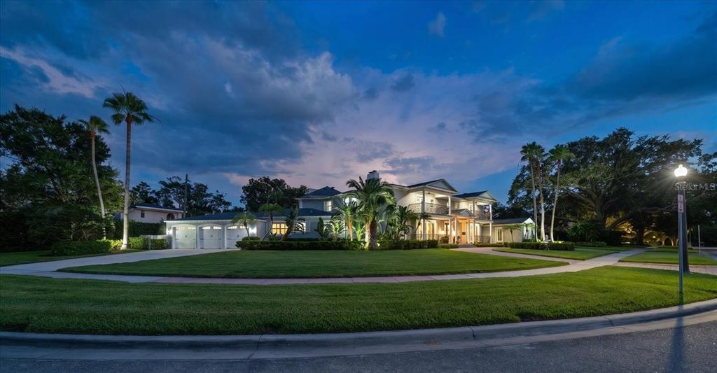 A large two-story house with a multi-car garage and palm trees at twilight — 155 WILLADEL DRIVE, BELLEAIR, FL