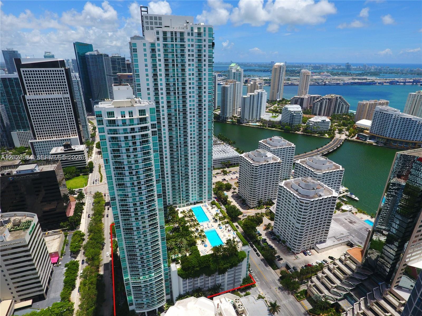 An aerial view shows a tall residential skyscraper with a pool deck and surrounding city — 950 Brickell Bay Dr # 1911, Miami FL 33131, MIAMI, FL