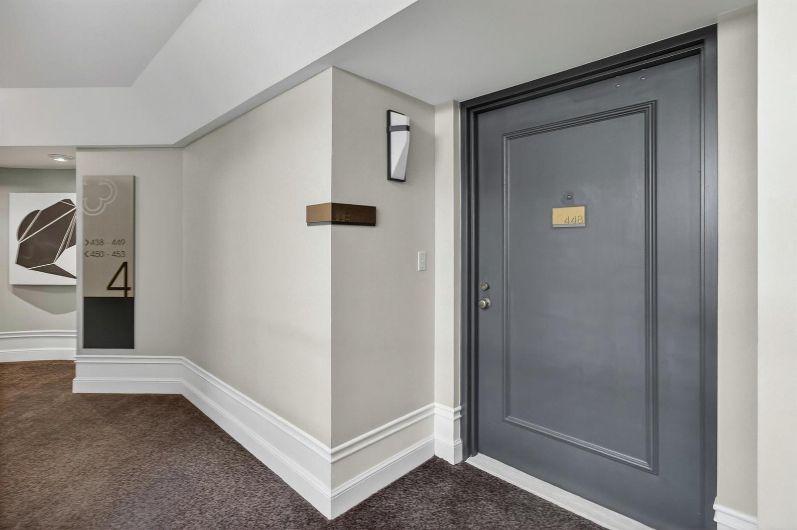 A gray apartment door labeled 448 is located in a carpeted hallway with beige walls — 140 SE 5th Avenue # 448, Boca Raton FL 33432, BOCA RATON, FL