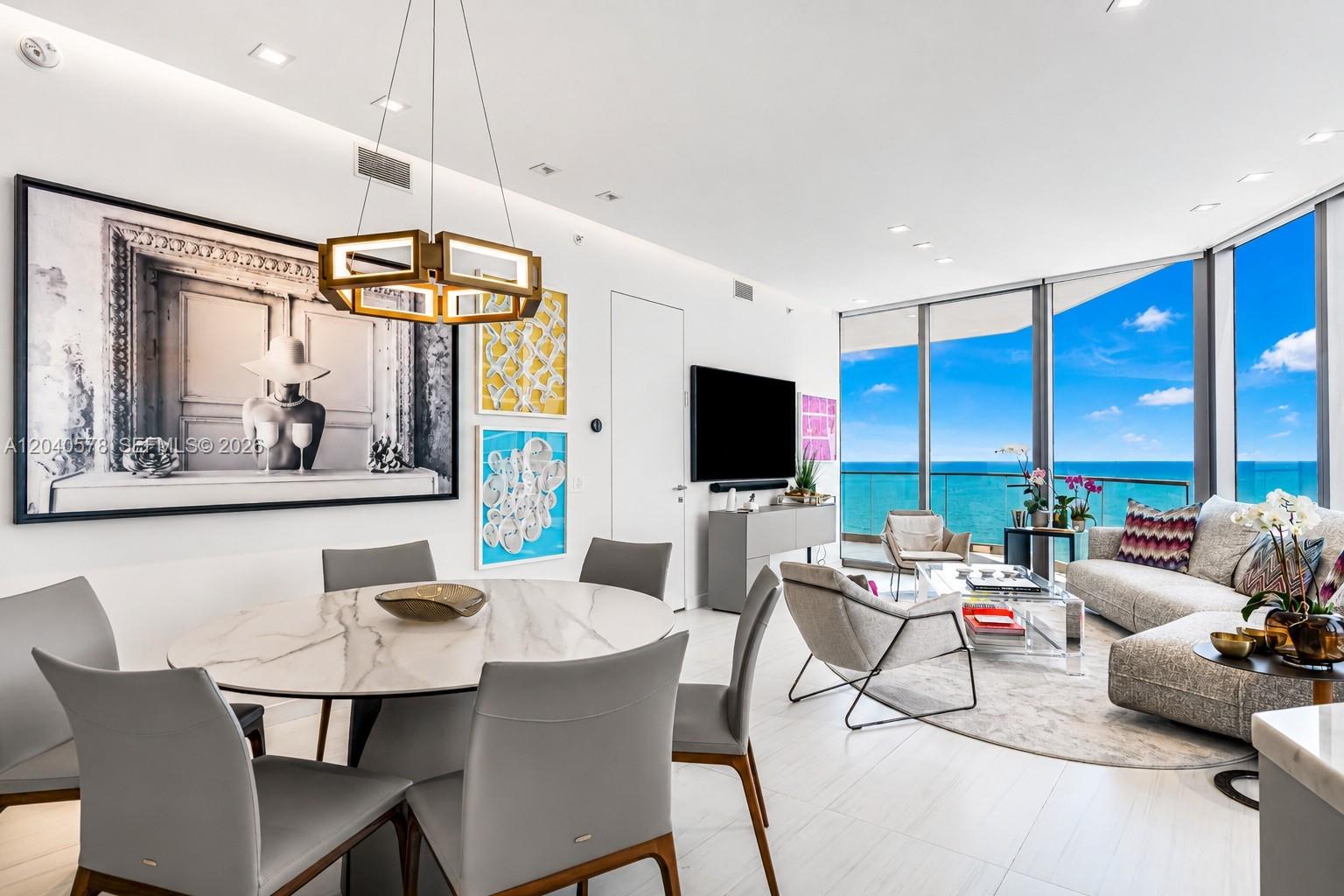 A modern open-concept living and dining area features floor-to-ceiling windows with ocean views — 18975 Collins Ave # 2004, Sunny Isles Beach FL 33160, SUNNY ISLES BEACH, FL