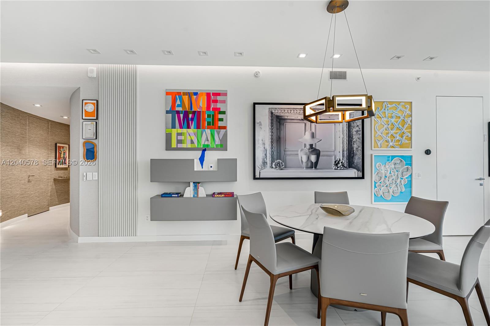 A modern dining room features a marble table, gray chairs, and colorful wall art — 18975 Collins Ave # 2004, Sunny Isles Beach FL 33160, SUNNY ISLES BEACH, FL