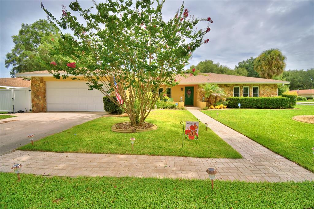 A single-story house with a stone facade, a two-car garage, and a paved walkway — 902 CRESTVIEW DRIVE, AUBURNDALE, FL
