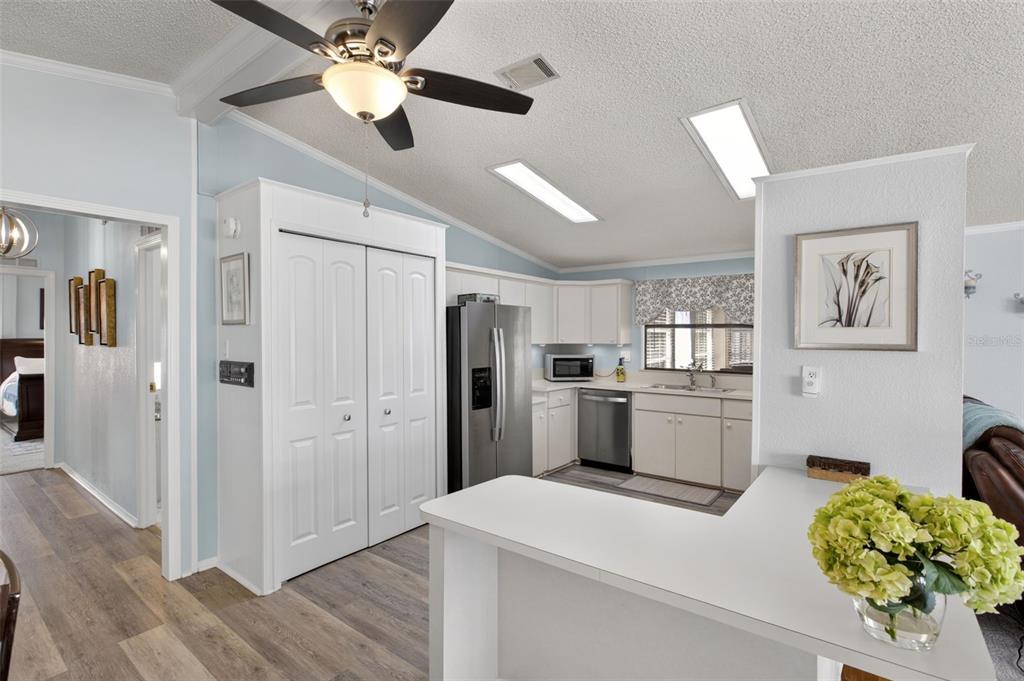 A kitchen with white cabinets, stainless steel appliances, and a breakfast bar — 487 LOMA LINDA, NORTH PORT, FL