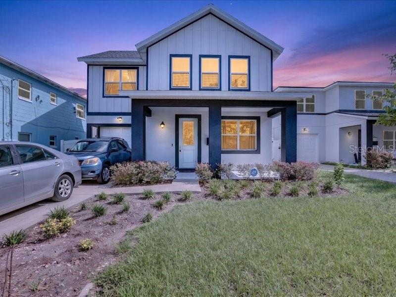 A two-story house with white vertical siding and a dark-framed front porch at dusk — 909 RANDALL STREET, ORLANDO, FL