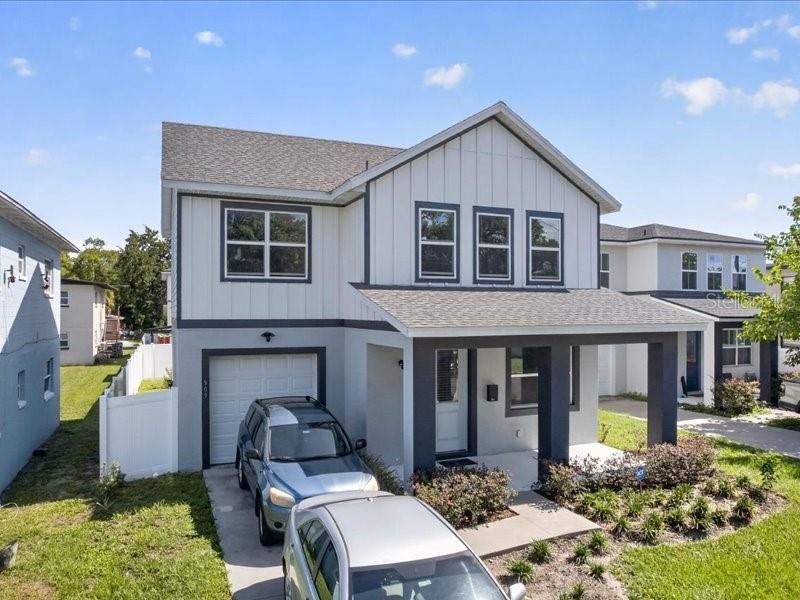A two-story house with white vertical siding, a gray garage, and a covered front porch — 909 RANDALL STREET, ORLANDO, FL