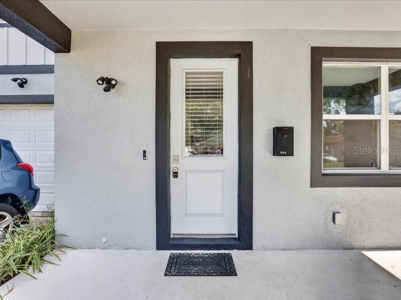 A white front door with a window sits on a porch next to a garage — 909 RANDALL STREET, ORLANDO, FL