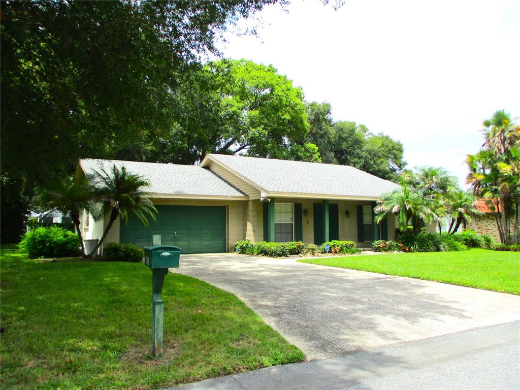 A single-story brick house with a green garage door and a concrete driveway — 1118 KNIGHTS PLACE, LAKELAND, FL