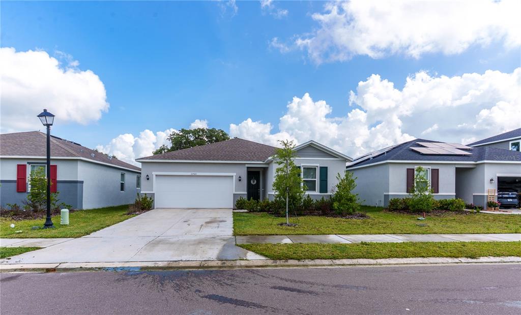 A single-story suburban house with a two-car garage and a concrete driveway — 37501 WILLIAMETTE WAY, ZEPHYRHILLS, FL