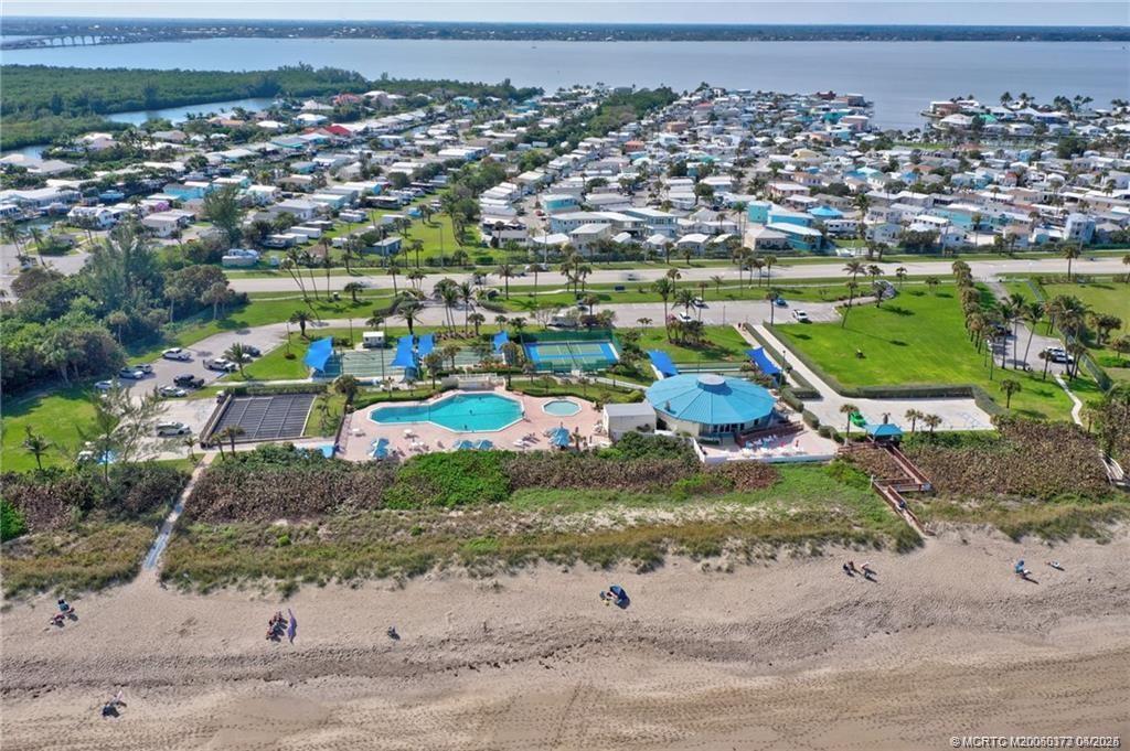 An aerial view shows a beach, a swimming pool, tennis courts, and a residential community — 10725 S Ocean Drive, Jensen Beach FL 34957, JENSEN BEACH, FL