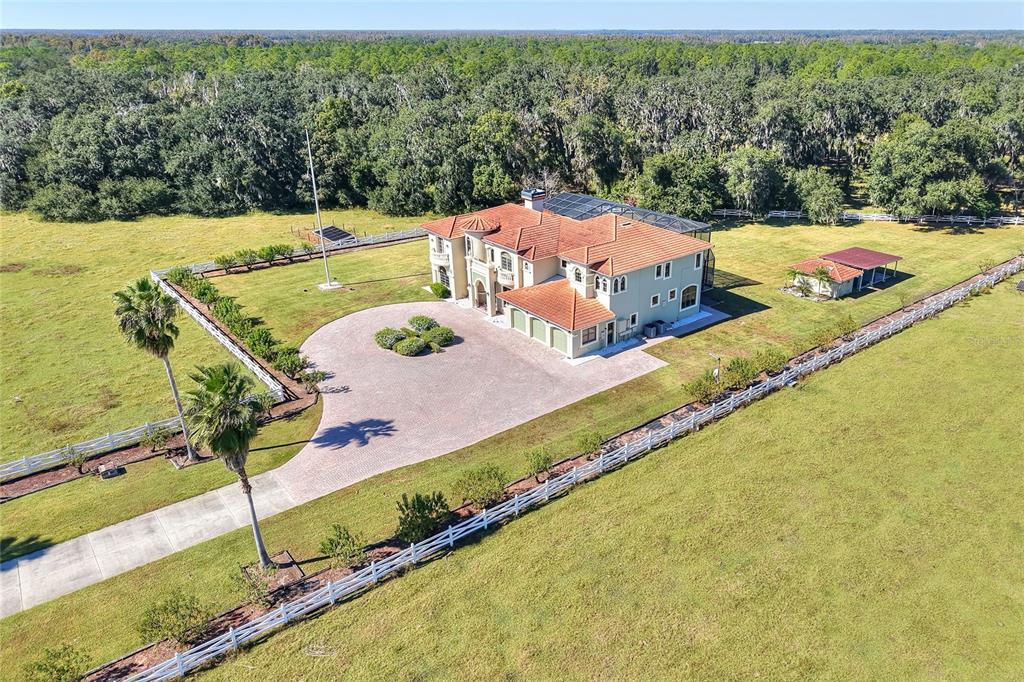 An aerial view shows a large house with a tile roof, circular driveway, and fenced yard — 4215 S B MERRION ROAD, LAKELAND, FL