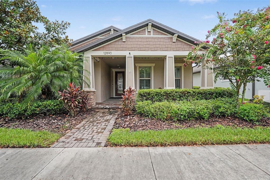 A single-story house with a covered front porch, brick walkway, and landscaped front yard — 12890 PAYTON STREET, ODESSA, FL
