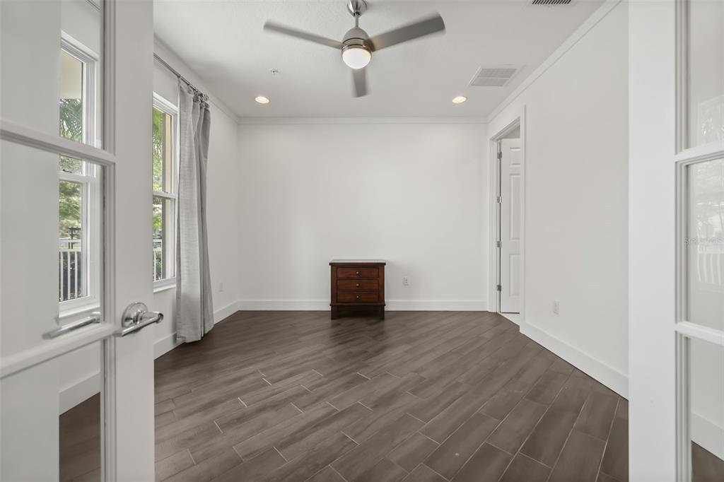 An empty room with white walls, dark wood-look tile flooring, and a ceiling fan — 789 GREYBULL RUN, LAKE MARY, FL