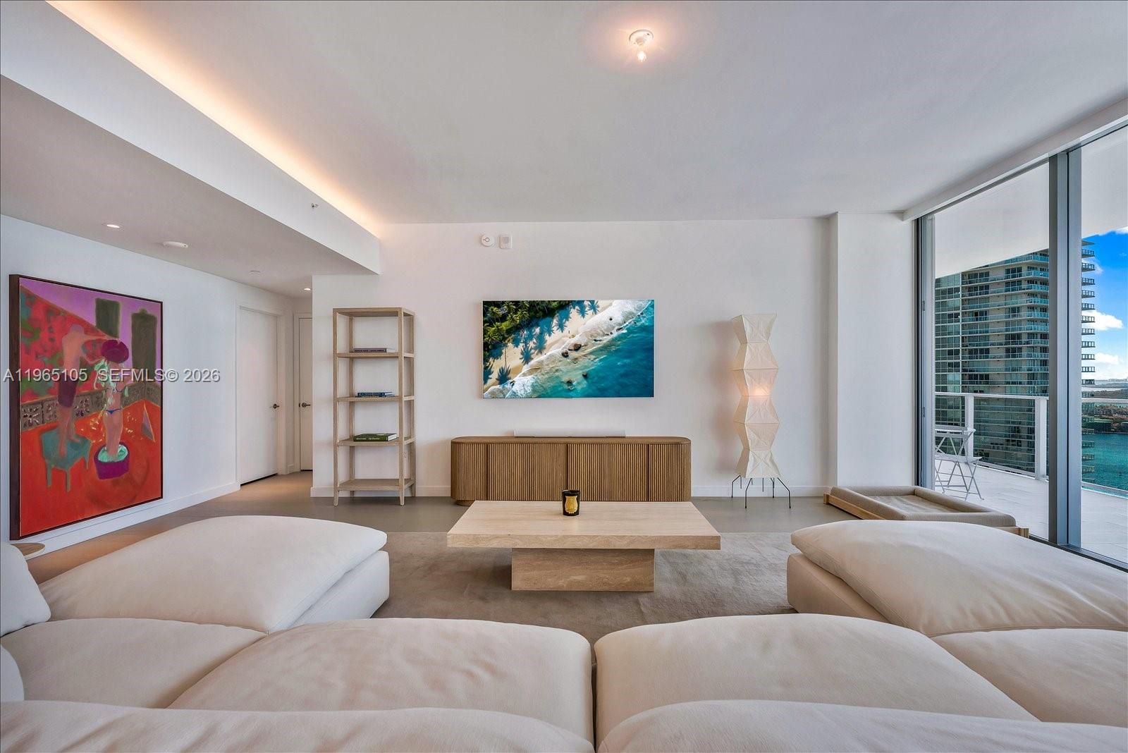 A modern living room features a white sectional sofa, a stone coffee table, and balcony views — 501 West Ave # 3102, Miami Beach FL 33139, MIAMI BEACH, FL