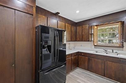 A kitchen features dark wood cabinets, a black refrigerator, and a window above the sink — 420 N FAIRVIEW AVENUE, DELAND, FL