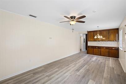 A room with light-colored walls, wood-look flooring, a ceiling fan, and built-in wooden cabinets — 420 N FAIRVIEW AVENUE, DELAND, FL
