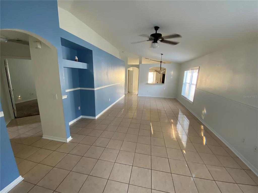 A living area features light-colored tile flooring, blue accent walls, and a ceiling fan — 8530 QUARTER HORSE DRIVE, RIVERVIEW, FL