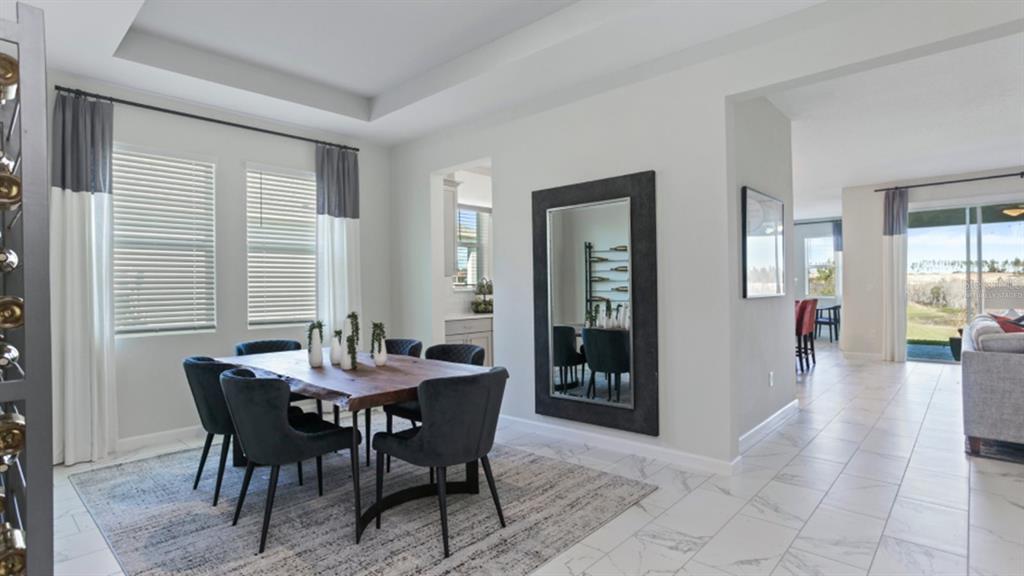 A dining room with a live-edge wood table, dark chairs, and a large wall mirror — 3116 NAMASTE DRIVE, CLERMONT, FL