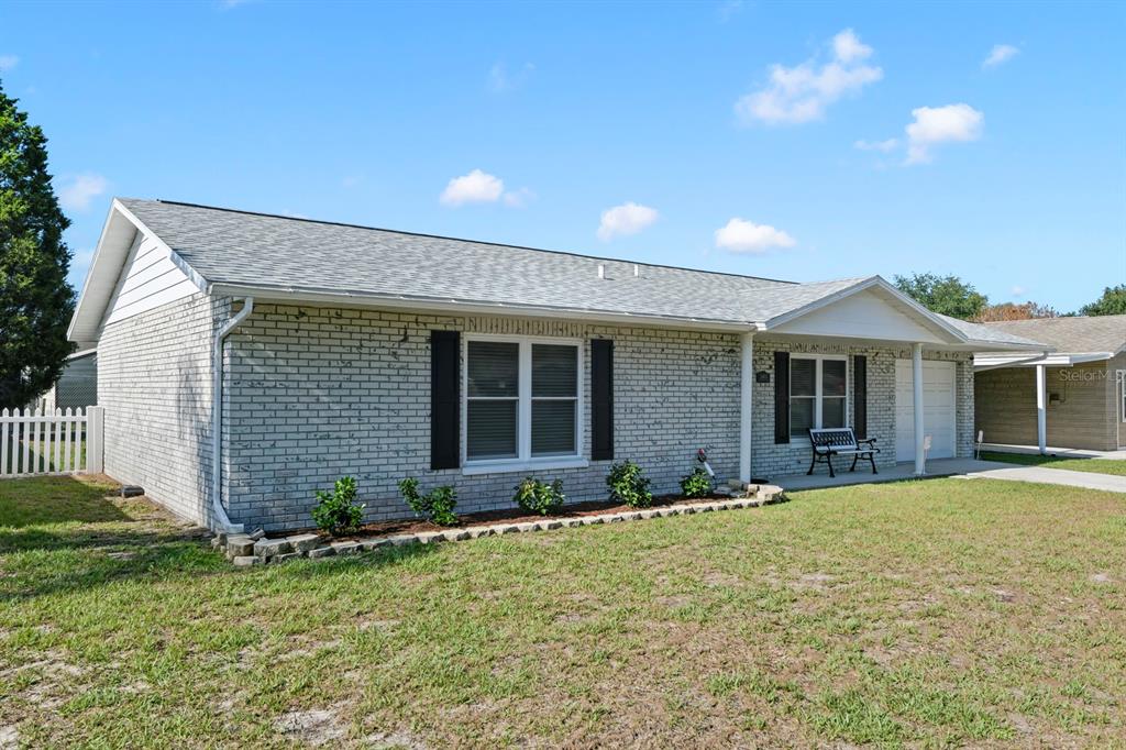 A single-story house with a light gray brick exterior, a shingled roof, and black shutters — 11403 FILLMORE AVENUE, SEFFNER, FL