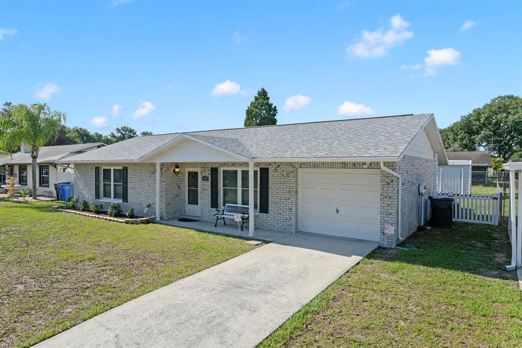 A single-story brick house with a white garage door, a front porch, and a driveway — 11403 FILLMORE AVENUE, SEFFNER, FL