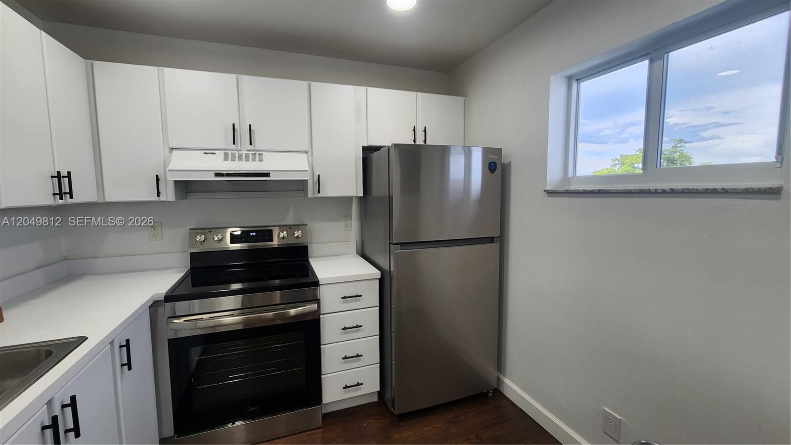 A kitchen features white cabinets, stainless steel appliances, and a window on a gray wall — 7541 NW 16th St # 1507, Plantation FL 33313, PLANTATION, FL