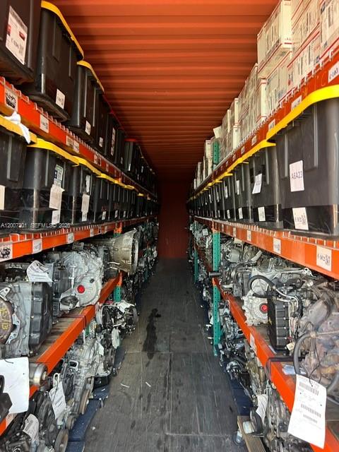 A shipping container is filled with rows of automotive parts stored on metal shelving units — NW 47th St, Miami FL 33142, MIAMI, FL