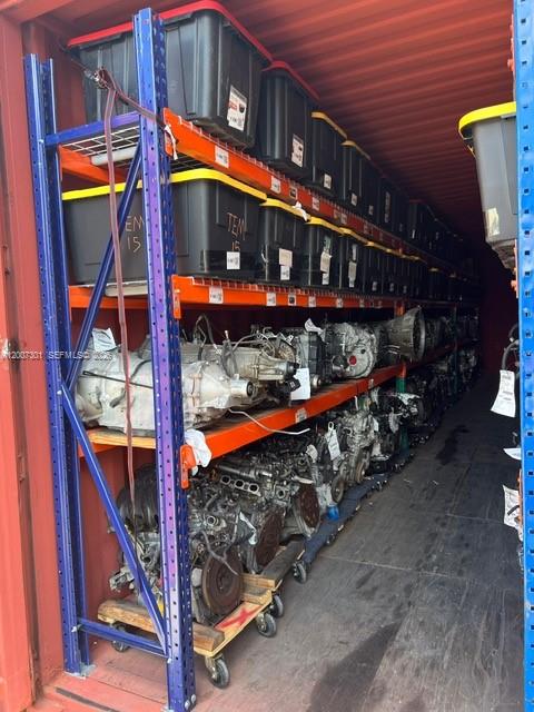 A shipping container is filled with industrial shelving units holding plastic storage bins and engines — NW 47th St, Miami FL 33142, MIAMI, FL
