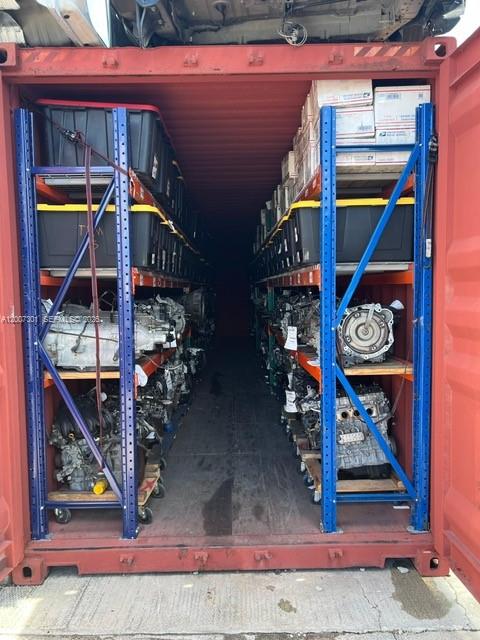A shipping container is organized with blue metal shelving units holding automotive parts and storage bins — NW 47th St, Miami FL 33142, MIAMI, FL