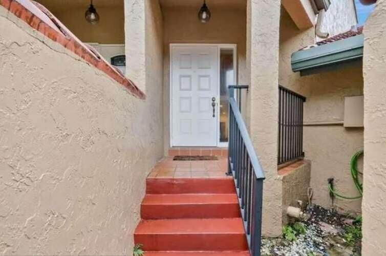 A white front door is reached by a set of red concrete steps — 9231 W Sunrise Boulevard, Plantation FL 33322, PLANTATION, FL
