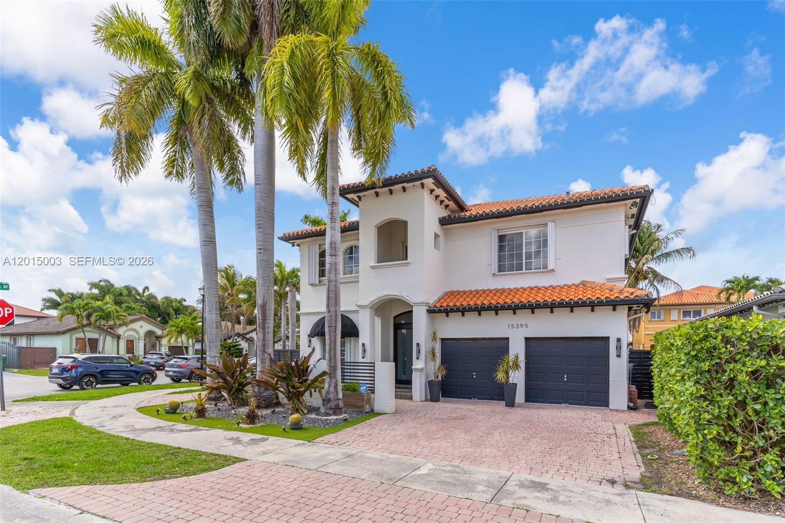A two-story stucco house features a tile roof, two garage doors, and tall palm trees — 15395 SW 23rd St, Miami FL 33185, MIAMI, FL