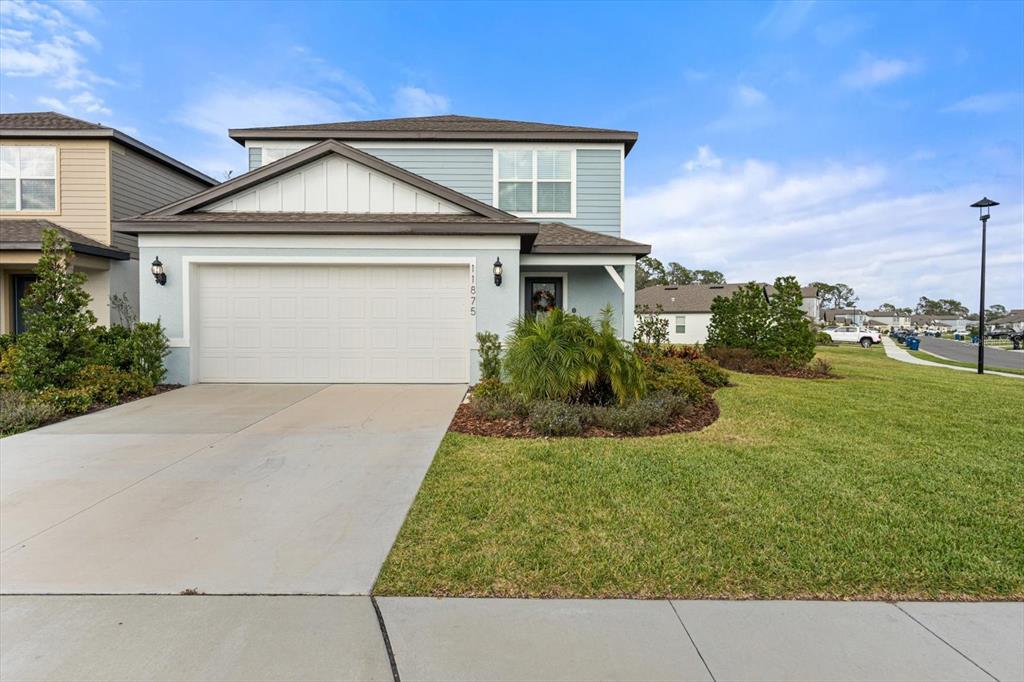 A two-story light blue house features a two-car garage and a front lawn — 11875 ARMADA WAY, PARRISH, FL