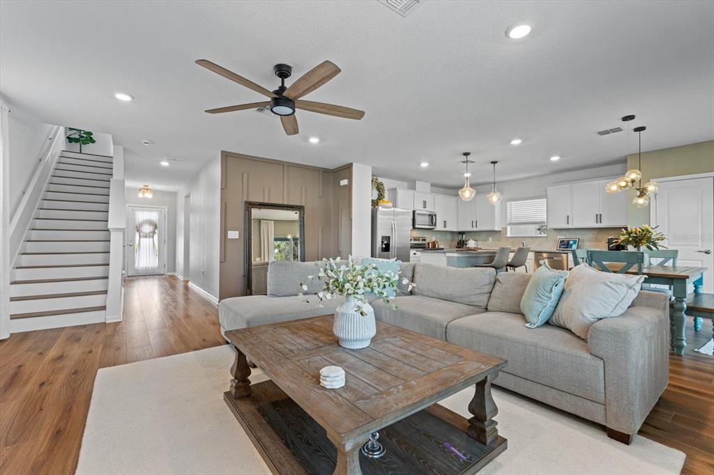 A living room with a sectional sofa, wooden coffee table, and an adjacent open kitchen — 11875 ARMADA WAY, PARRISH, FL