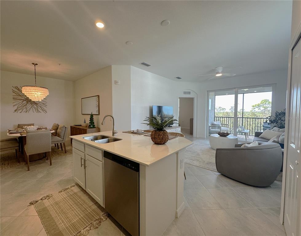 An open-concept kitchen with a central island overlooks a dining area and a living room — 14201 HERITAGE LANDING BOULEVARD UNIT 1338, PUNTA GORDA, FL