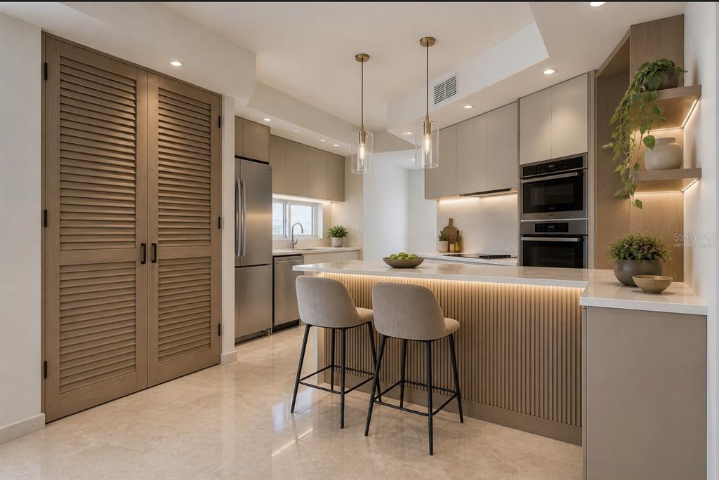 A modern kitchen features a breakfast bar with stools, stainless steel appliances, and wood cabinetry — 1754 MCCLEARY AVENUE UNIT 602, SAN JUAN, PR